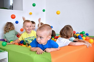 dzieci bawiące sie w basenie z kolorowymi kulkami