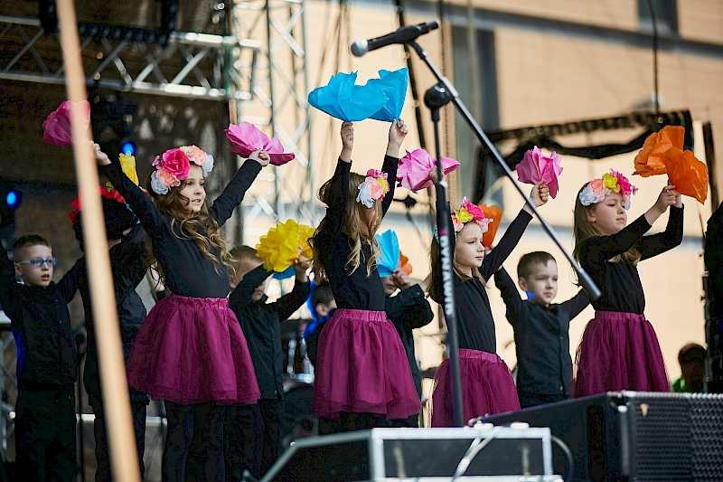 Obraz przedstawia dziewczynki występujące na scenie.