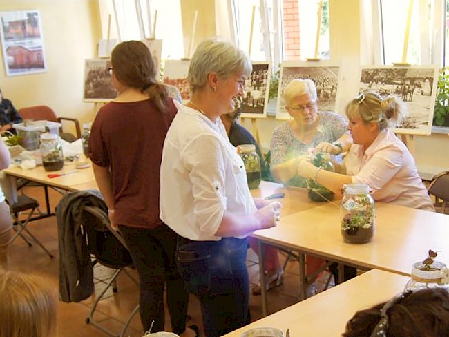 Warsztaty podczas zajęć z seniorami. Na zdjęciu kobiety robią stroiki ze słoików