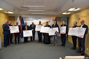 Grupowe zdjęcie beneficjentów dofinansowania z marszałkiem Jarosławem Stawiarskim.